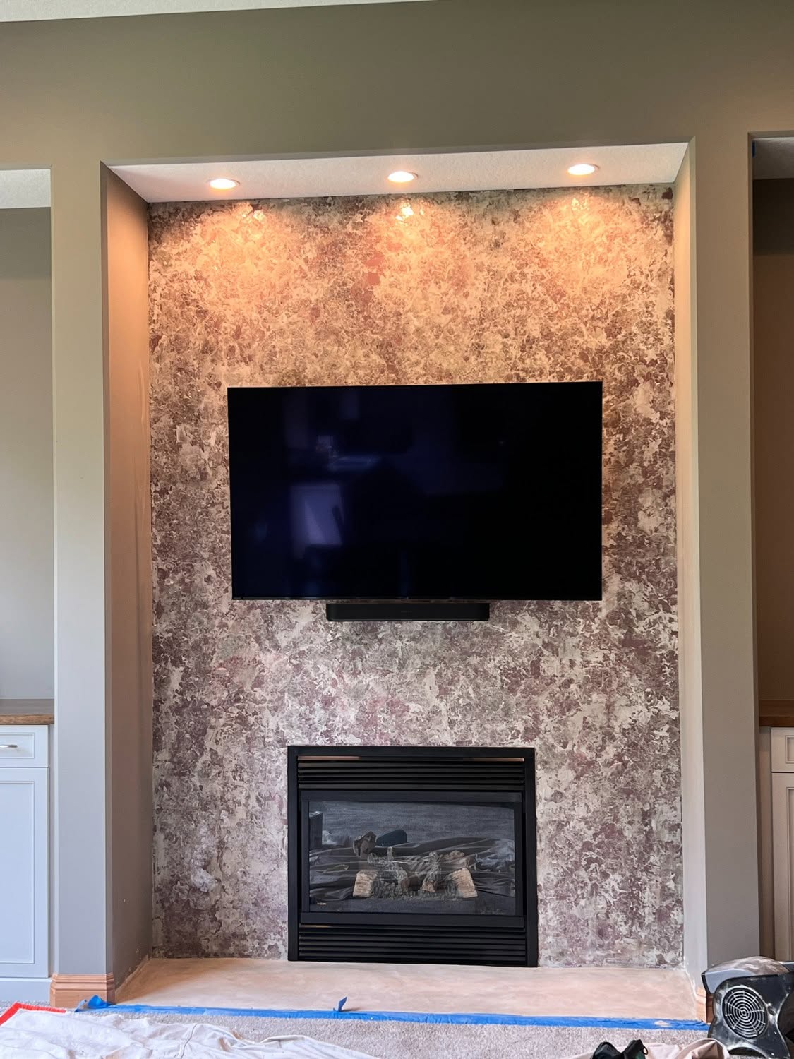 Layered decorative finish on a fireplace feature wall